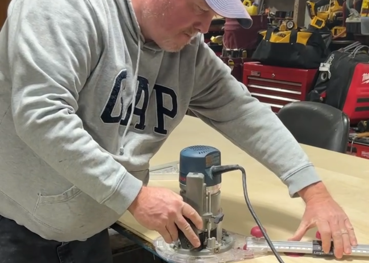 Person using a drill on a workbench in a workshop setting